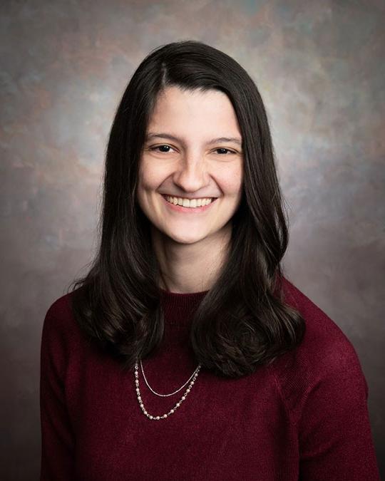 headshot of woman with long dark hair smiling