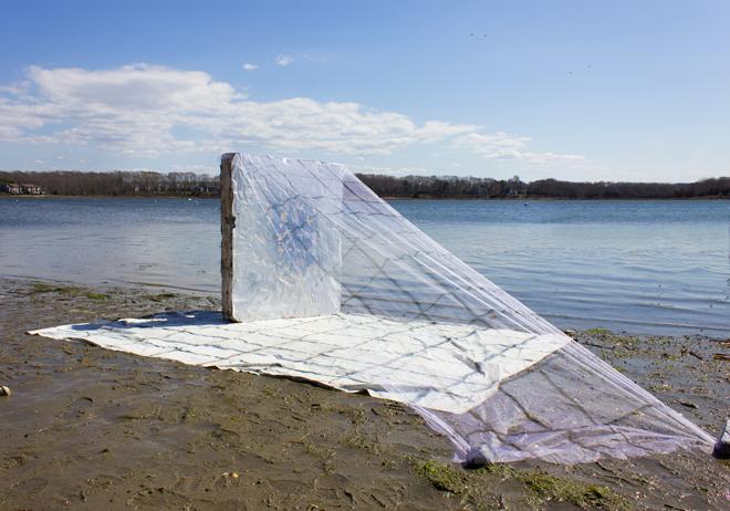 painting of blanket, a vertical block, with draping mesh on a beach